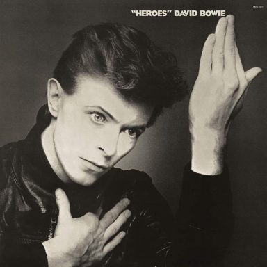 Portada del álbum "Heroes" de David Bowie, con un fondo oscuro y un gesto característico.