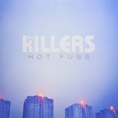 Portada del álbum "Hot Fuss" de The Killers, con un fondo azul y edificios altos.